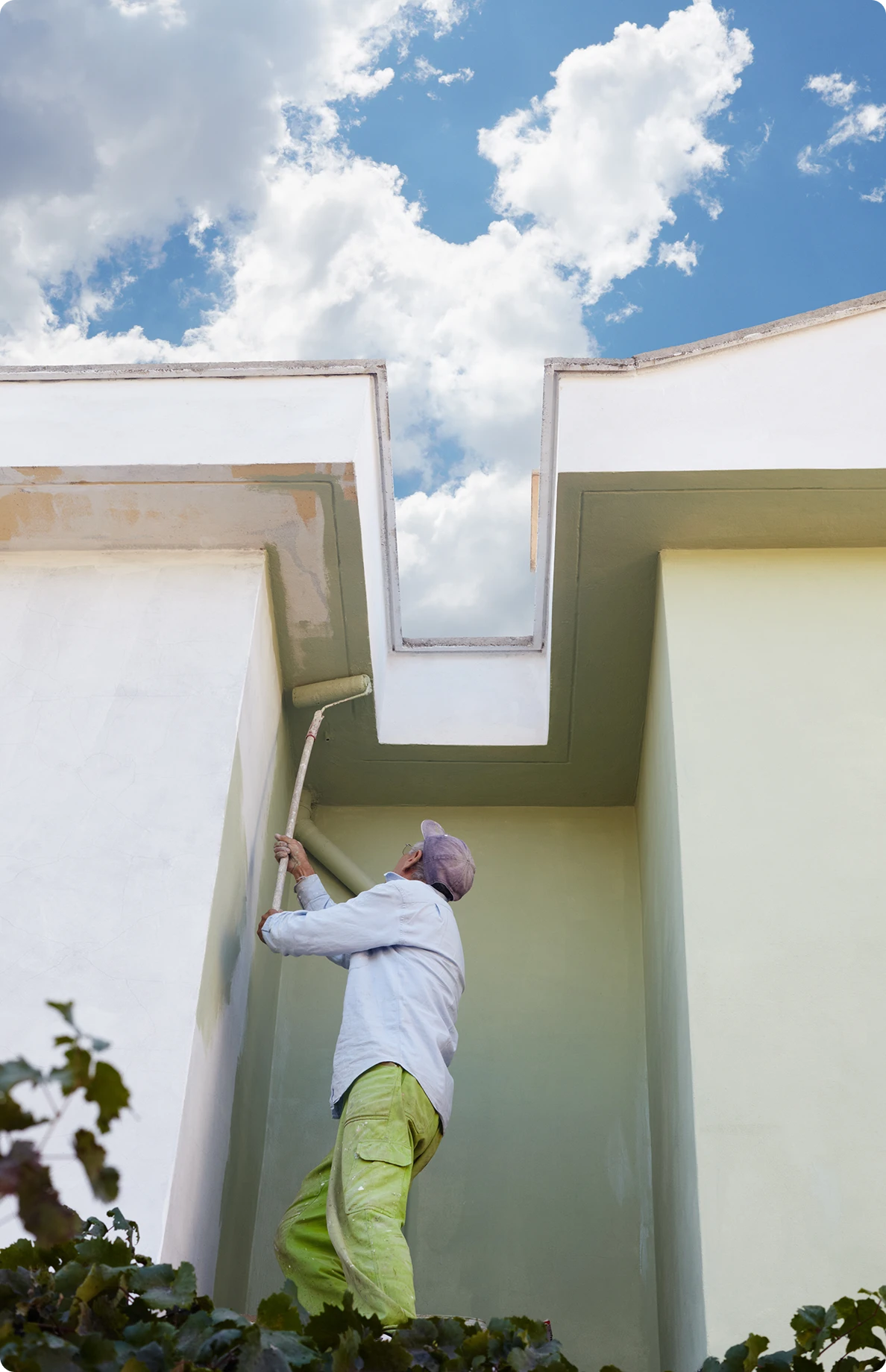 Painter working on tall building facade