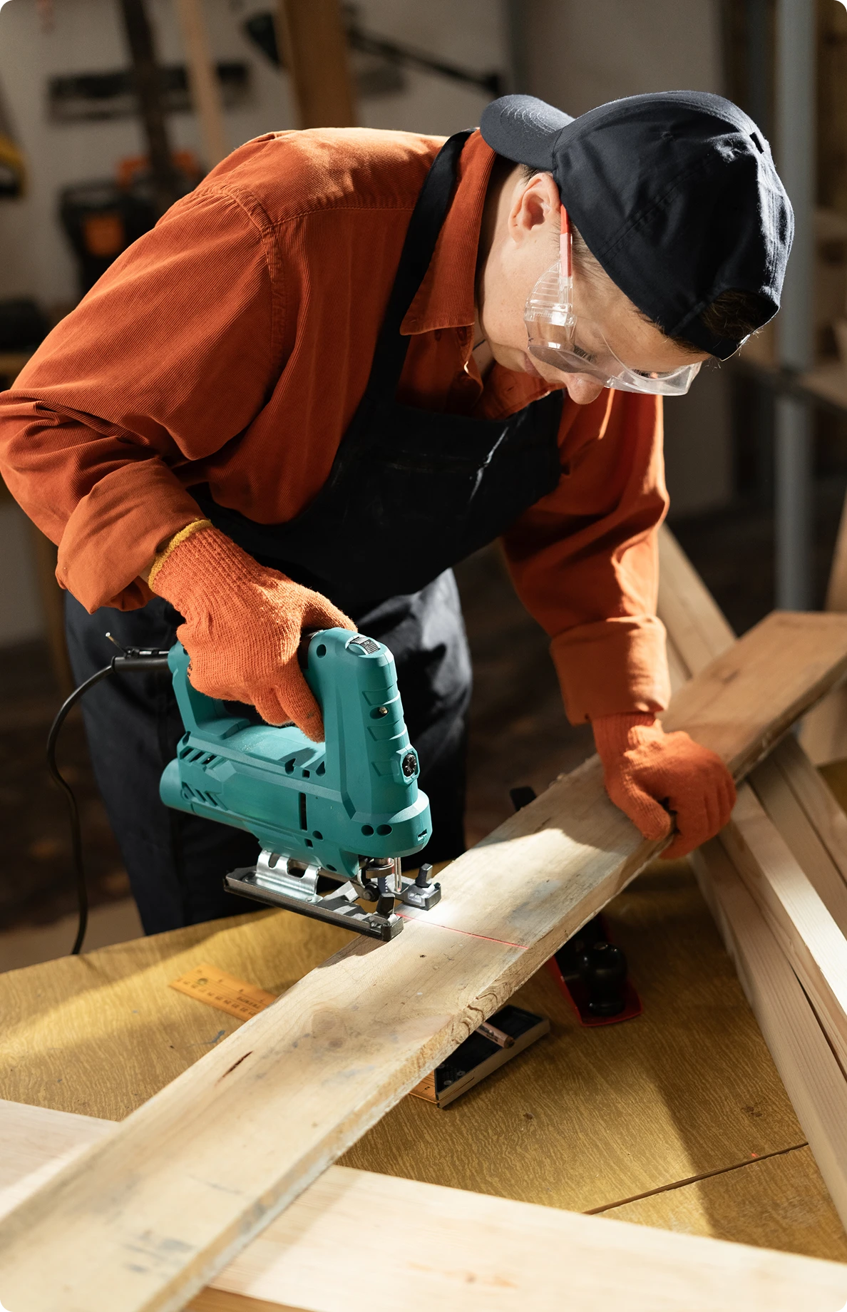 Carpenter wearing safety gear while sawing