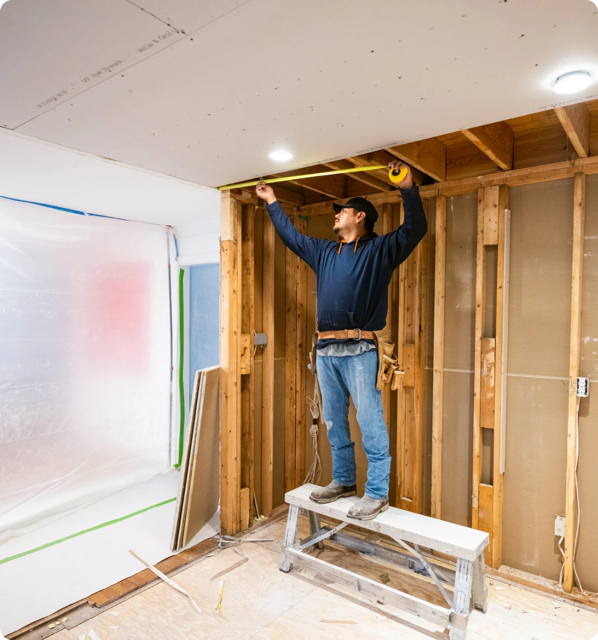 Worker standing on ladder in construction site