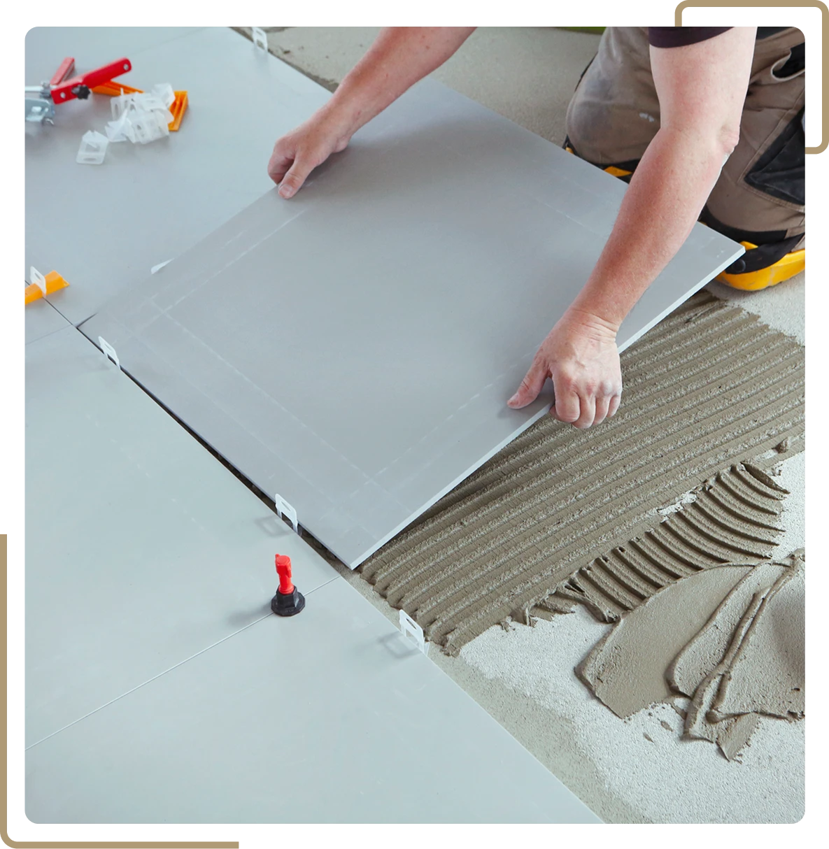 Worker placing ceramic tiles on floor