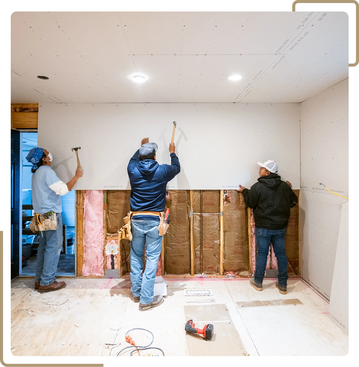 Workers installing drywall in a room