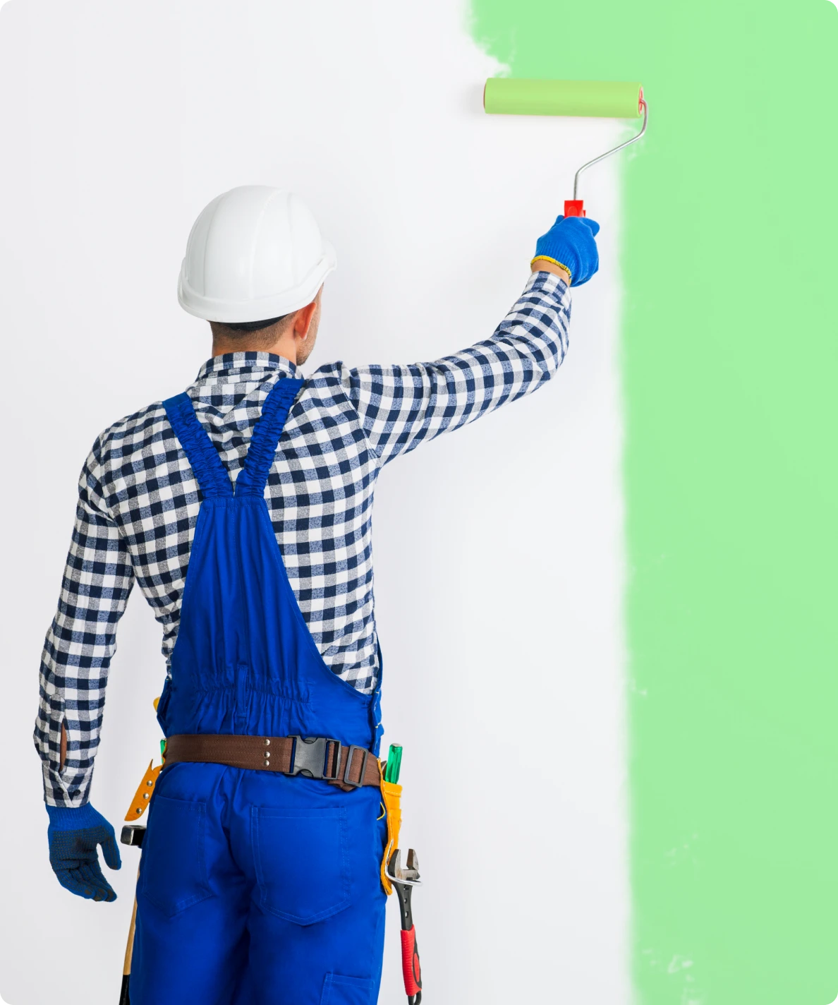 Painter transforming wall with green paint
